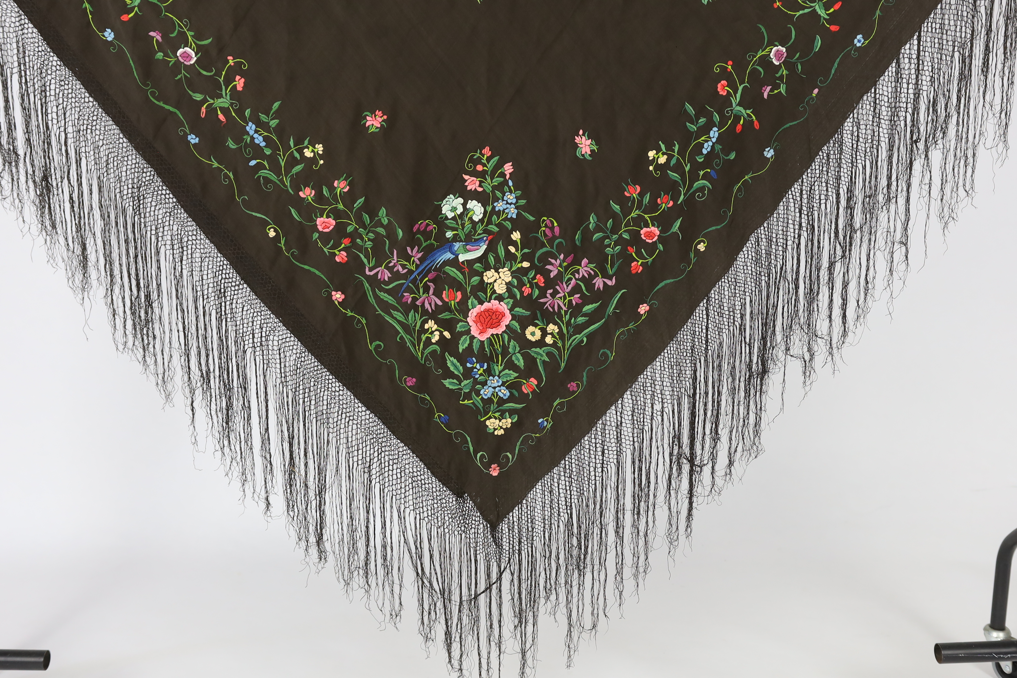 A Chinese silk shawl, circa 1900, embroidered with polychrome threads with birds and flowers against a black silk ground, 164cm sq.